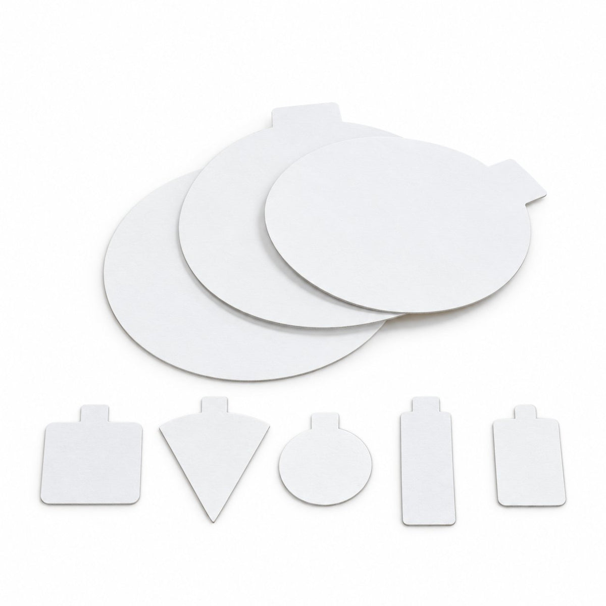 White individual pastry boards in triangular, square, round and cigar shapes