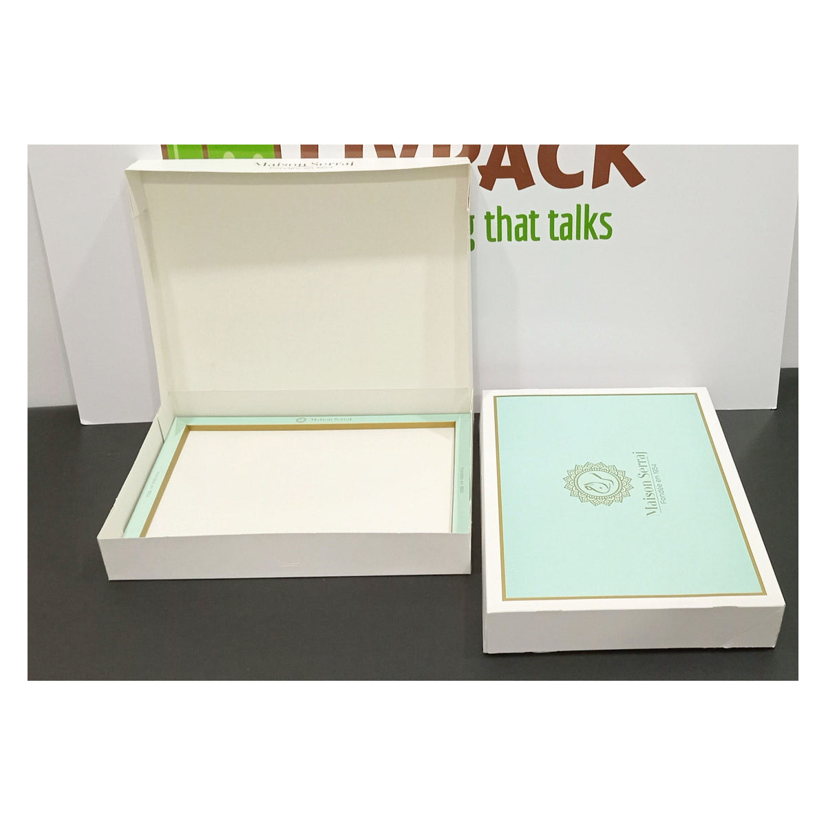 Cajas de pastelería apiladas con logos y varios tamaños