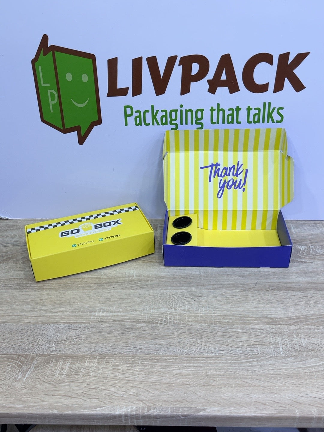 Photo réelle des coffrets personnalisés jaune et bleu devant le fond LIVPACK